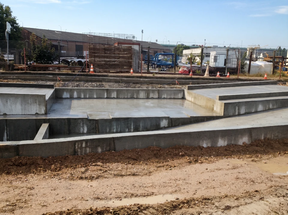 Chantier de construction extérieur avec fondations en béton armé fraîchement coulées